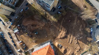 Binalar ve araçlar arasındaki kentsel alandaki bir peyzaj şantiyesinin hava görüntüsü.