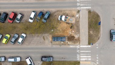 Bir yerleşim yerinin yanındaki inşaat alanının havadan görüntüsü. Bölge, işçiler ve cadde boyunca park halindeki çok sayıda araçla yenileniyor. Zemin kısmen kazılmış..
