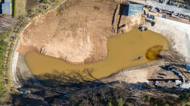 Büyük çamurlu su havuzu ve çevresindeki toprakla göl manzaralı bir havuz..