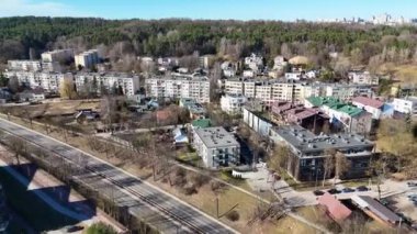 Apartman binaları, yollar ve ağaçlarla çevrili bir banliyö manzarası.