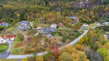 Sonbahar yapraklarıyla çevrili kırsal bir köyün havadan görünüşü..