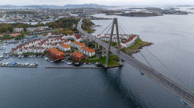 Köprüsü, kırmızı çatılı evleri ve marinası olan kıyı kasabasının havadan görünüşü..