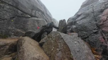 Sisli bir günde büyük kayaların arasına tırmandığım biri..