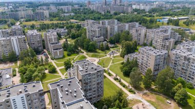 Yeşillik ve patikalarla çevrili birden fazla apartmanı olan bir yerleşim bölgesinin havadan görüntüsü..