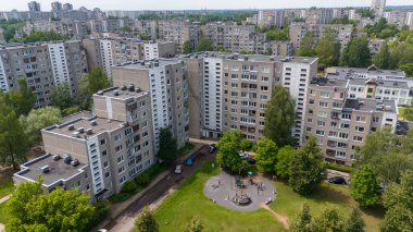 Sovyet tarzı apartman binaları ve çocuk parkı olan bir yerleşim yeri manzarası..