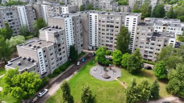 Birkaç apartman binası ve ağaçlarla çevrili oyun parkı olan bir yerleşim bölgesinin havadan görüntüsü..