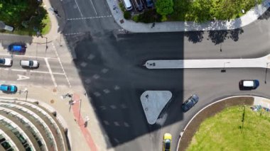 Arabalarla ve üçgen bir trafik adasıyla şehir kavşağının havadan görüntüsü..
