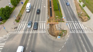 Araçlar, yaya geçitleri ve boru hattı inşaatı yapılan işlek bir şehir kavşağının hava görüntüsü