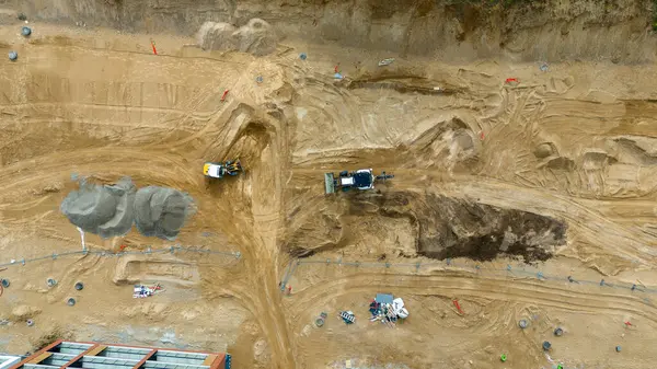 Ağır makineli ve çamurlu bir inşaat alanının havadan görüntüsü.