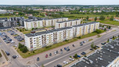 Birden fazla apartmanı ve park halindeki arabaları olan bir yerleşim bölgesinin havadan görüntüsü..