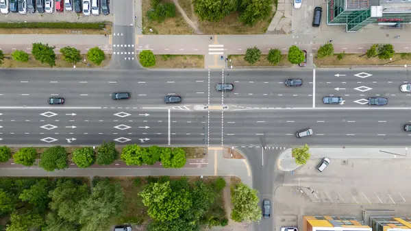 Çoklu şeritli ve arabalı işlek bir şehir kavşağının hava görüntüsü.