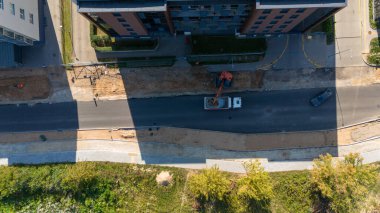 Eski kiremitleri söken kazıcının bulunduğu bir şehrin havadan görünüşü.