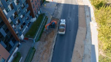 Eski kiremitleri söken kazıcının bulunduğu bir şehrin havadan görünüşü.