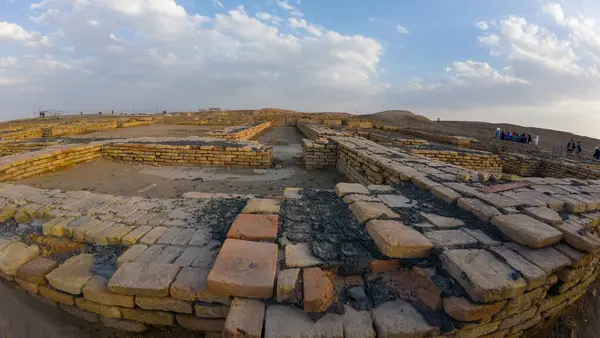 Irak 'ın Ur kentinin antik harabeleri. Bulutlu bir gökyüzünün altında taş duvarlar, tarihi mimari sergileniyor..