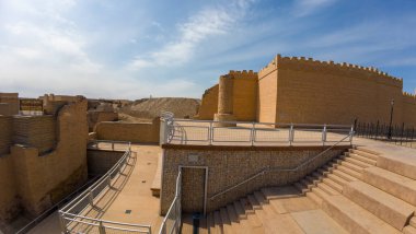 Mavi gökyüzünün altında yeniden inşa edilmiş duvarları ve yolları olan antik kalıntılar..