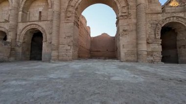 Uzun duvarları ve berrak mavi gökyüzü olan antik taş kalıntıları..