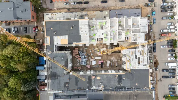Vinçleri ve kısmen inşa edilmiş yapıları olan bir inşaat alanının havadan görüntüsü.