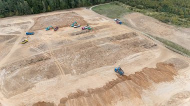 Ağır makineler ve toprak işçiliğiyle büyük bir inşaat alanının havadan görüntüsü.