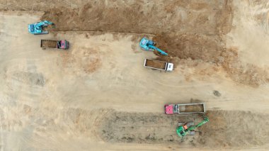 Kazıcıların çöp kamyonlarını yüklediği inşaat alanının havadan görüntüsü.