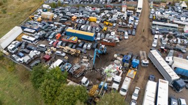 Kalabalık bir hurdalığın hava manzarası, sayısız araba, kamyon ve hurda metal..