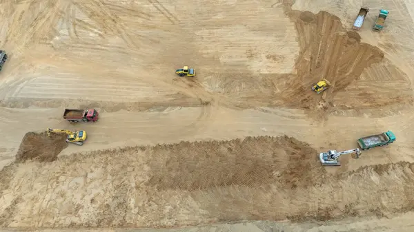 Ağır makinelerin yer değiştirdiği bir inşaat alanının havadan görüntüsü.