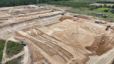 Toprağı hareket ettiren ekipman ve araçlarla büyük bir inşaat alanının havadan görüntüsü..