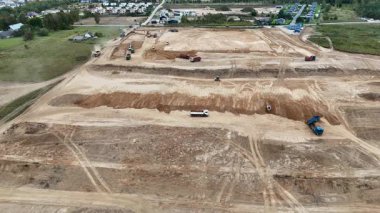 Toprağı hareket ettiren araçların araziyi hazırladığı bir inşaat alanının havadan görüntüsü..