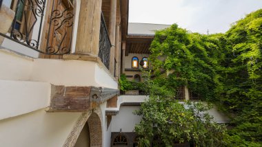 Yeşillik ve ahşap mimari unsurları olan geleneksel bir avlu. Şam 'ın eski kasabasında