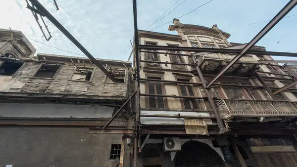 Metal iskeleti ve yıpranmış dış görünüşü olan eski, harap bir bina. Şam 'ın eski kasabasında