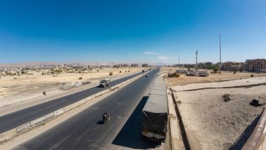 Çölün ortasında seyrek trafik ve açık mavi gökyüzü olan geniş bir otoyol. Suriye 'nin Şam Jobar ilçesinde