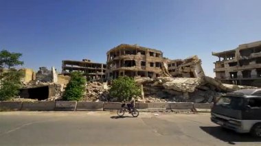 Yıkılan binaların ve enkazların olduğu bir yıkım sahnesi. Yapılarda hasar izleri var. Duvarlar çökmüş ve iç kısımlar ortaya çıkmış. Suriye 'nin Şam Jobar ilçesinde