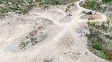Makine ve toprak yollu bir kum ocağının havadan görünüşü.