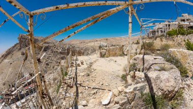 Kayalık bir çöl manzarasına bakan paslı metal çerçeve berrak mavi gökyüzü.