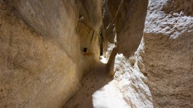 Dar kayalık geçit, dokulu duvarlar, güneş ışığı, gölgeler..