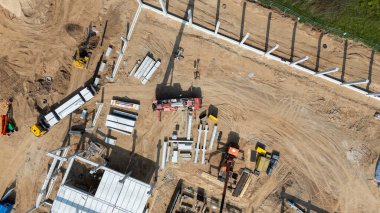 Makine ve inşaat malzemeleri olan bir inşaat alanının havadan görüntüsü.