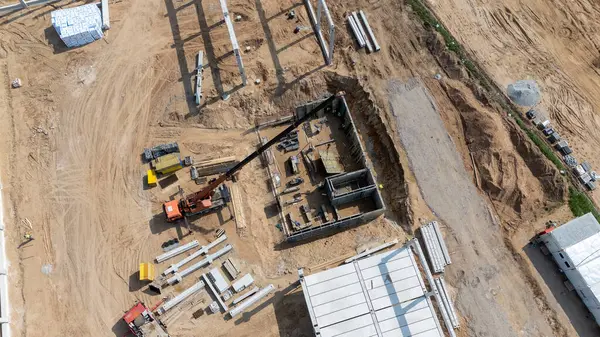 Makine ve inşaat malzemeleri olan bir inşaat alanının havadan görüntüsü.