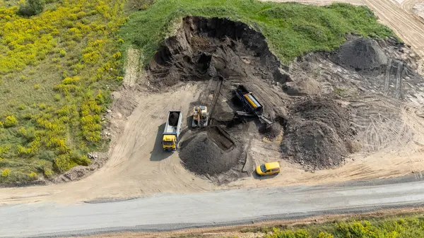 Ağır makineli ve araçlı bir inşaat alanının havadan görüntüsü.
