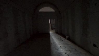 Gölgeli ve dokulu duvarları olan loş ışıklı bir koridor. Eski IŞİD gizli askeri üssü. Suriye, Palmira.