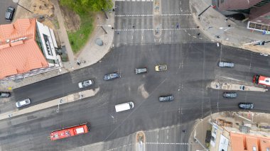Araçlar ve yayalarla dolu işlek bir şehir kavşağının hava görüntüsü.