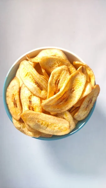 Banana Chips Una Ciotola Bianca Blu Sfondo Bianco Pronto Vendita — Foto Stock