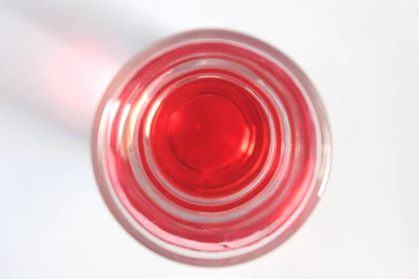 Wazig Beeld Van Rode Drank Klein Glas Bovenaanzicht Witte Achtergrond — Stockfoto