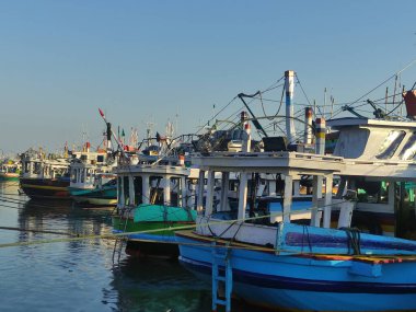 Paiton, Probolinggo, Doğu Java, Endonezya kıyılarındaki geleneksel bir limana demirlemiş baskın bir mavi tekne.
