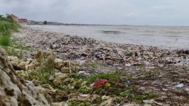 Plajın kenarındaki çöp yığınları temizlenmemiş.
