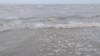 Öğleden sonra kumsalın küçük dalgaları