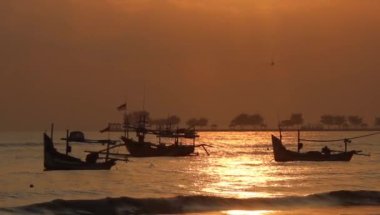 Kırmızı gün doğumu, balıkçı tekneleri demirliyor.