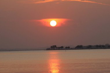 Sabah kumsalında kırmızı turuncu gün doğumu