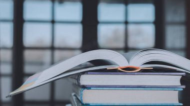 Ahşap masanın üzerine eski kitap yığını ya da plie. Öğrenme, eğitim ve öğrenim kavramı. Bir tanesi kopyalama alanı ile açılır.