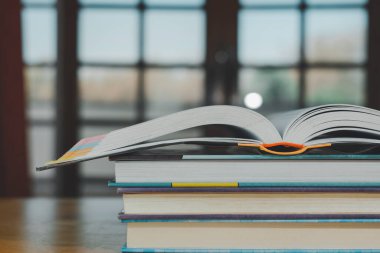 Ahşap masanın üzerine eski kitap yığını ya da plie. Öğrenme, eğitim ve öğrenim kavramı. Bir tanesi kopyalama alanı ile açılır.