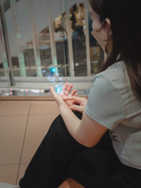 Woman using Info graphics shopping online icons on mobile smart phone e-Commerce, online banking payment and shopping online and social media concept at shopping mall colorful background