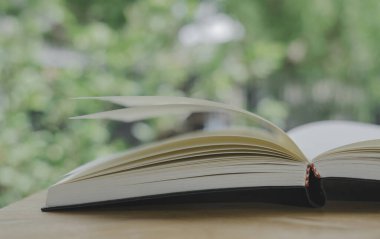 Ahşap masanın üzerine eski kitap yığını ya da plie. Öğrenme, eğitim ve öğrenim kavramı. Bir tanesi kopyalama alanı ile açılır.